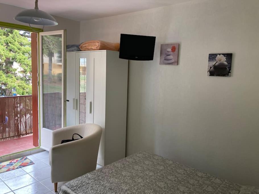 ein Schlafzimmer mit einem Bett und einem TV an der Wand in der Unterkunft Dans une station thermale, Studio dans résidence avec ascenseur in Amélie-les-Bains-Palalda