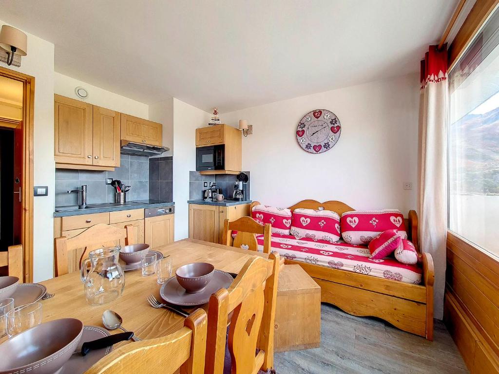 a kitchen and dining room with a table and a couch at Appartement rénové Au pied des pistes Balcon ouest - FR-1-344-769 in Les Menuires