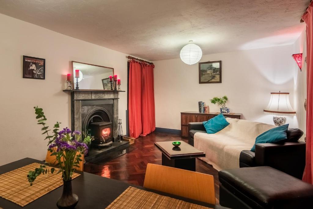 a living room with a couch and a fireplace at Mill Cottages at Kilcarbry House in Enniscorthy