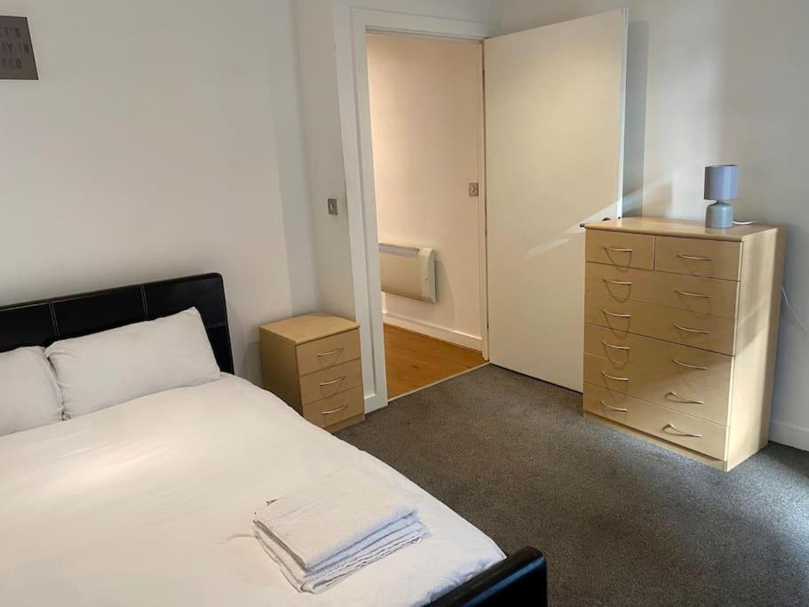 a bedroom with a white bed and a dresser at XL Corner Apartment w Gym & Spa in Manchester