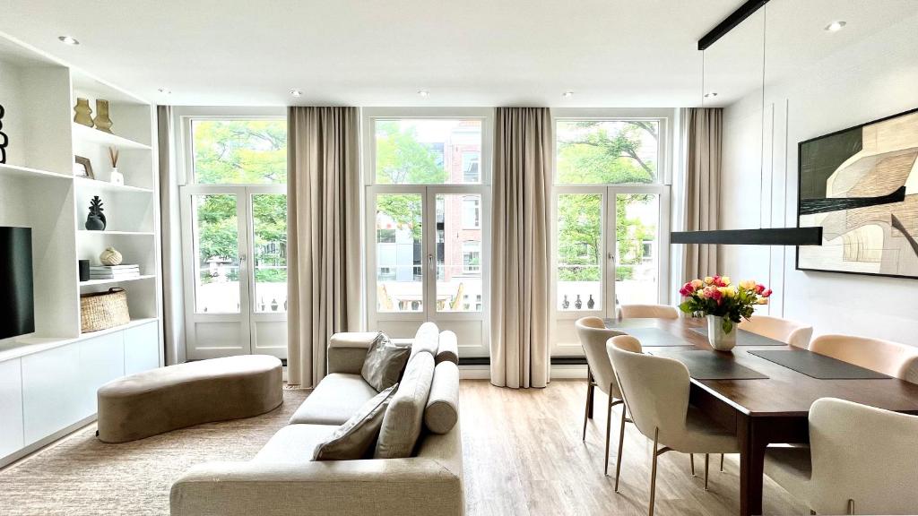 ein Wohnzimmer mit einem Sofa und einem Tisch in der Unterkunft New stylish 1 bedroom apt w/ 2 balconies in Centrum in Amsterdam