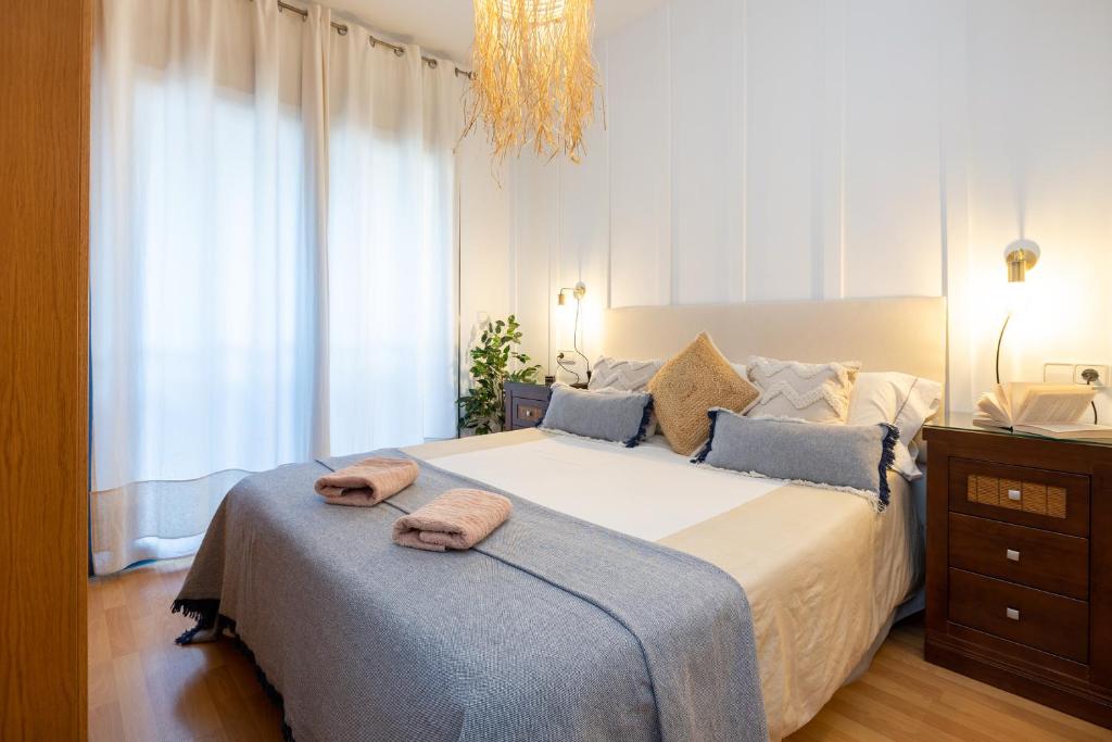 1 dormitorio con 1 cama grande y 2 toallas. en APARTAMENTOS ARCOIRIS, en Granada