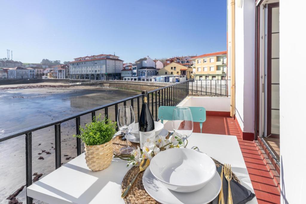 una mesa en un balcón con vistas al océano en LA CASA DEL RELOJ, en Luanco