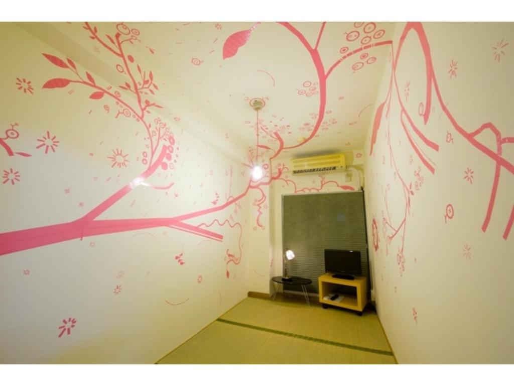 een kamer met een muur met een schilderij aan de muur bij Hostel Zen - Vacation STAY 91848v in Yokohama