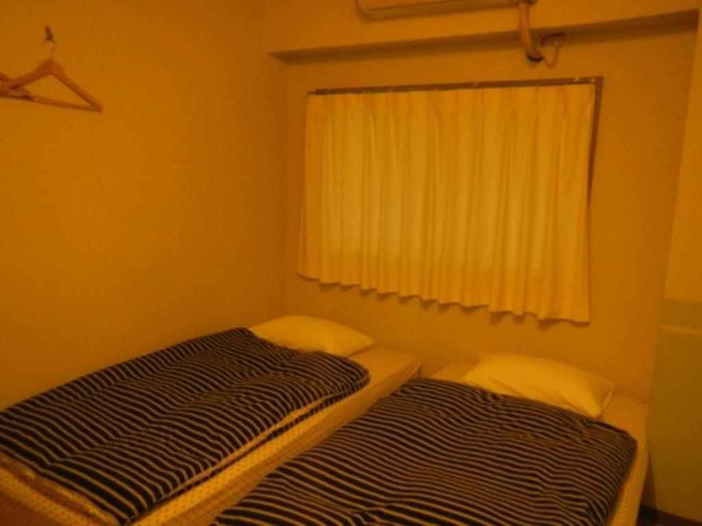 two beds in a small room with a window at Hostel Zen - Vacation STAY 91871v in Yokohama