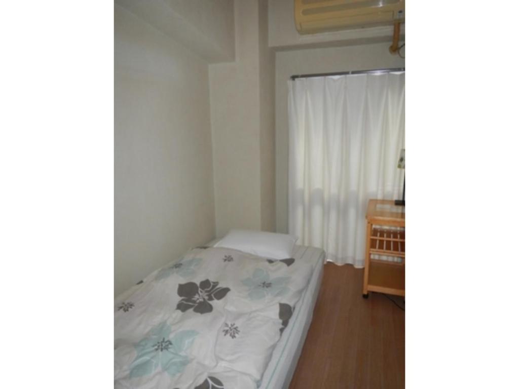a small bedroom with a bed and a window at Hostel Zen - Vacation STAY 91867v in Yokohama