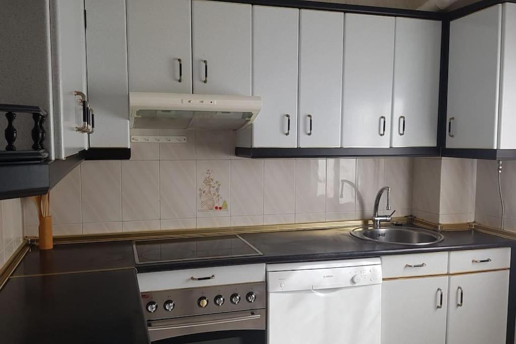 a kitchen with white cabinets and a sink at Adosado Dr Fleming 12 in Poyales del Hoyo