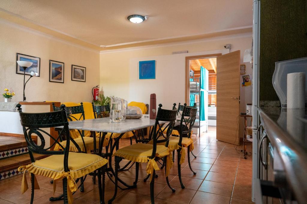 - une salle à manger avec une table et des chaises dans l'établissement Arena Nest Hostel, à Puerto de Santiago