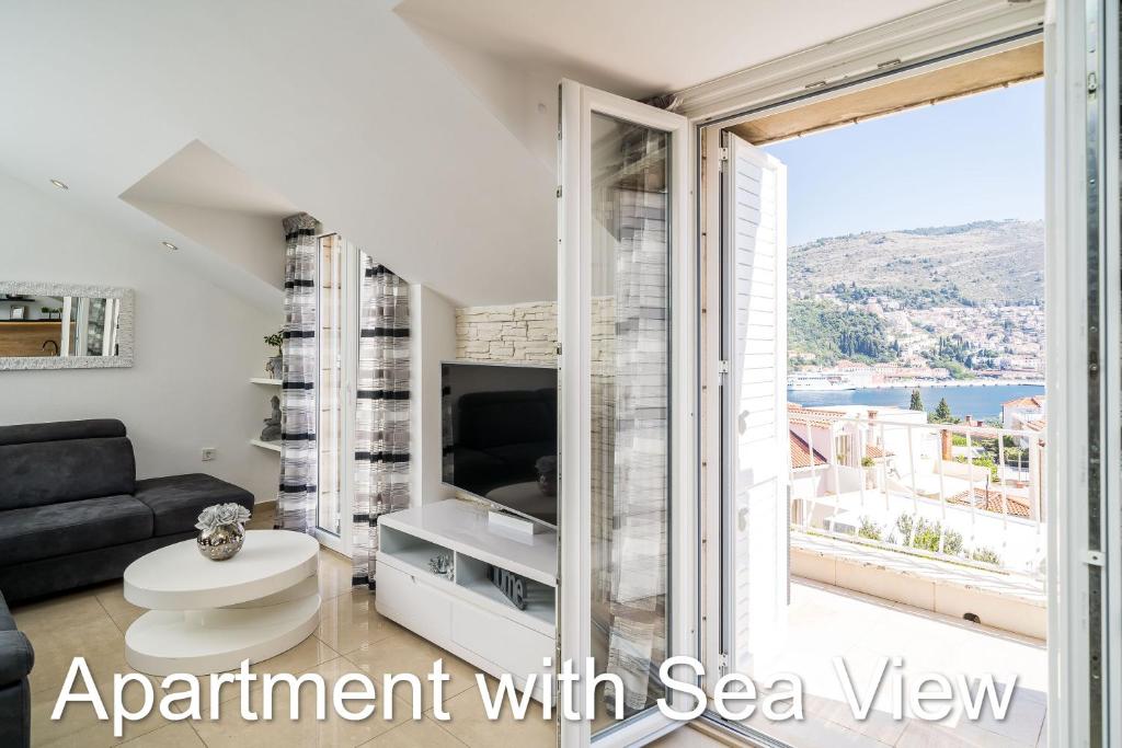 een woonkamer met een bank en een groot raam bij Apartments Budman in Dubrovnik