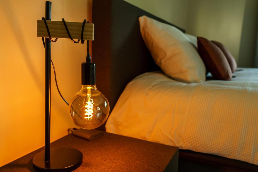 a lamp on a table next to a bed at B&B De Boskamp in Tegelen