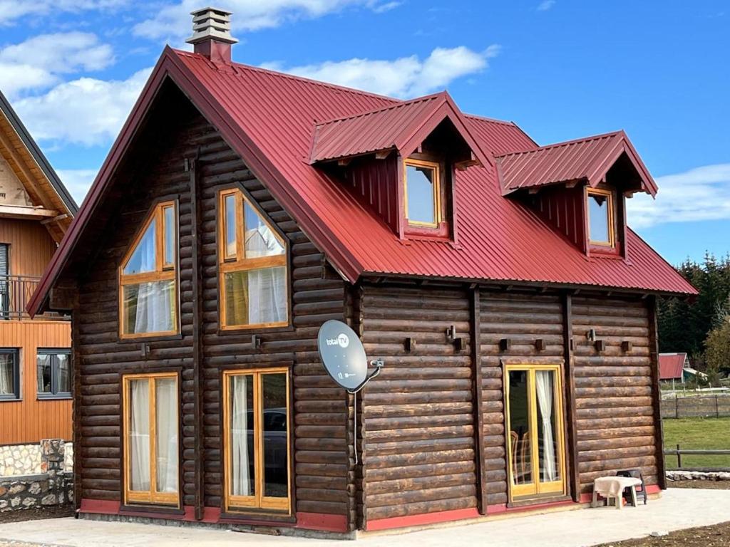 Cabaña de madera pequeña con techo rojo en Дом в Жабляке с шикарным видом на Дурмидор en Žabljak