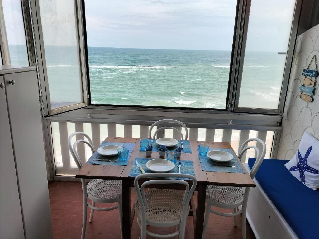 - une table et des chaises dans une chambre avec vue sur l'océan dans l'établissement Casa Mary, à Marotta