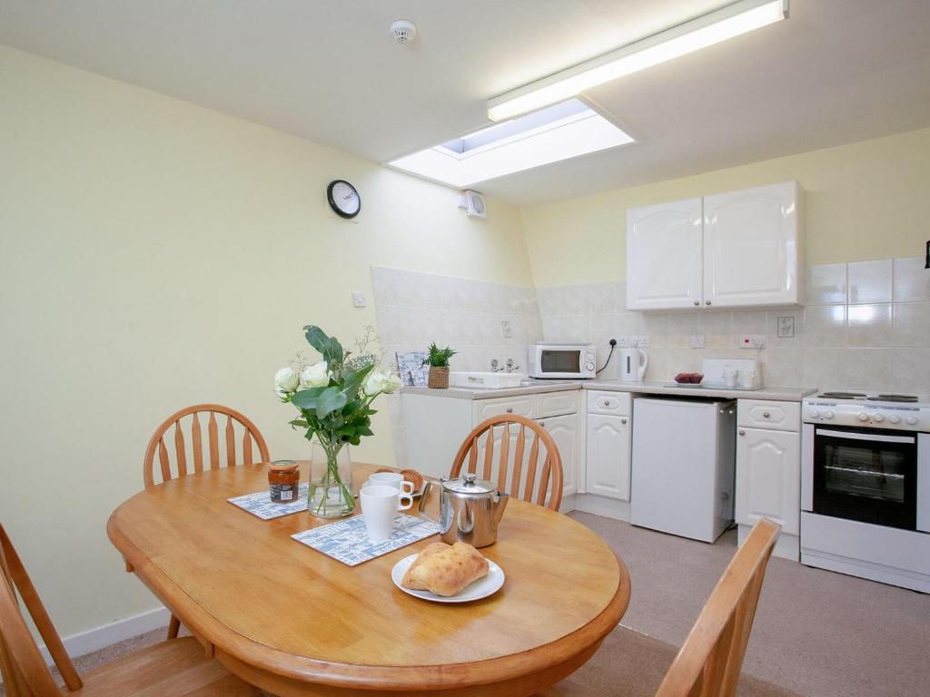 een keuken met een houten tafel met een bord eten erop bij Apartment Fourteen - Uk39870 in Paignton