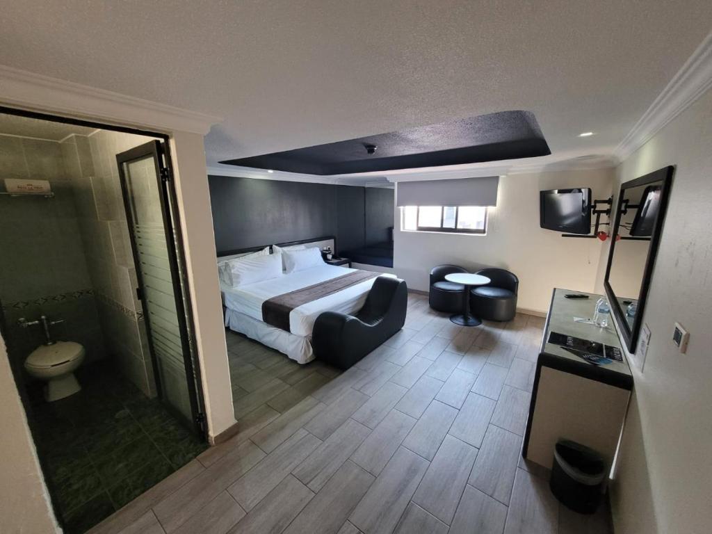 a hotel room with a bed and a bathroom at Real La Viga Motel in Mexico City
