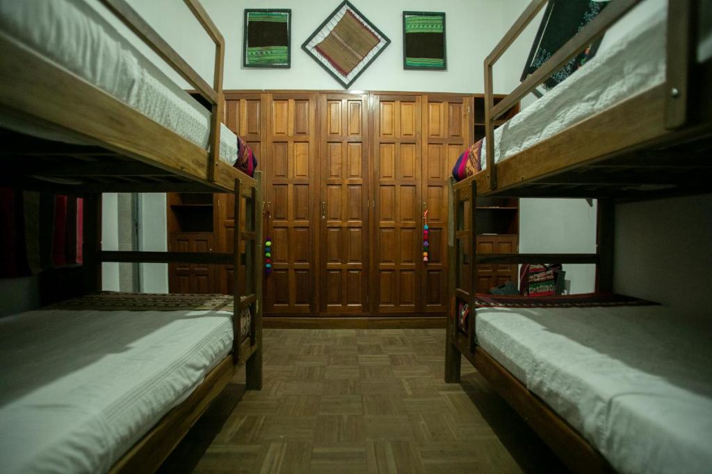 2 letti a castello in una camera con armadietti in legno. di Hostel Cultural Pata y Perro a Tarija
