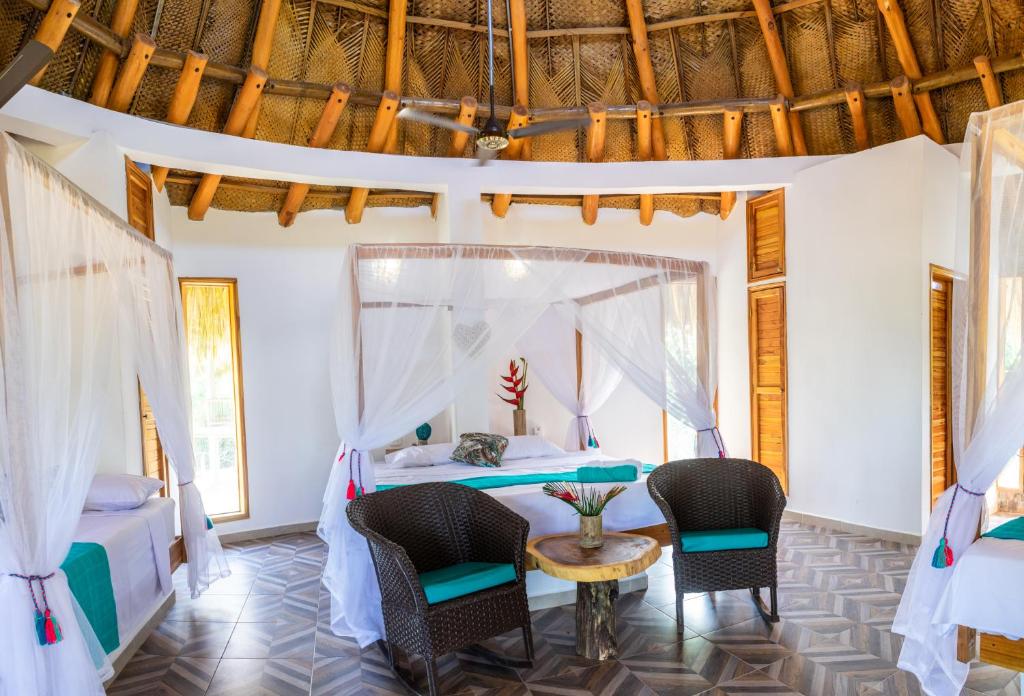 a bedroom with a bed and chairs and a table at UUTTAAKA Eco-Hotel in Palomino