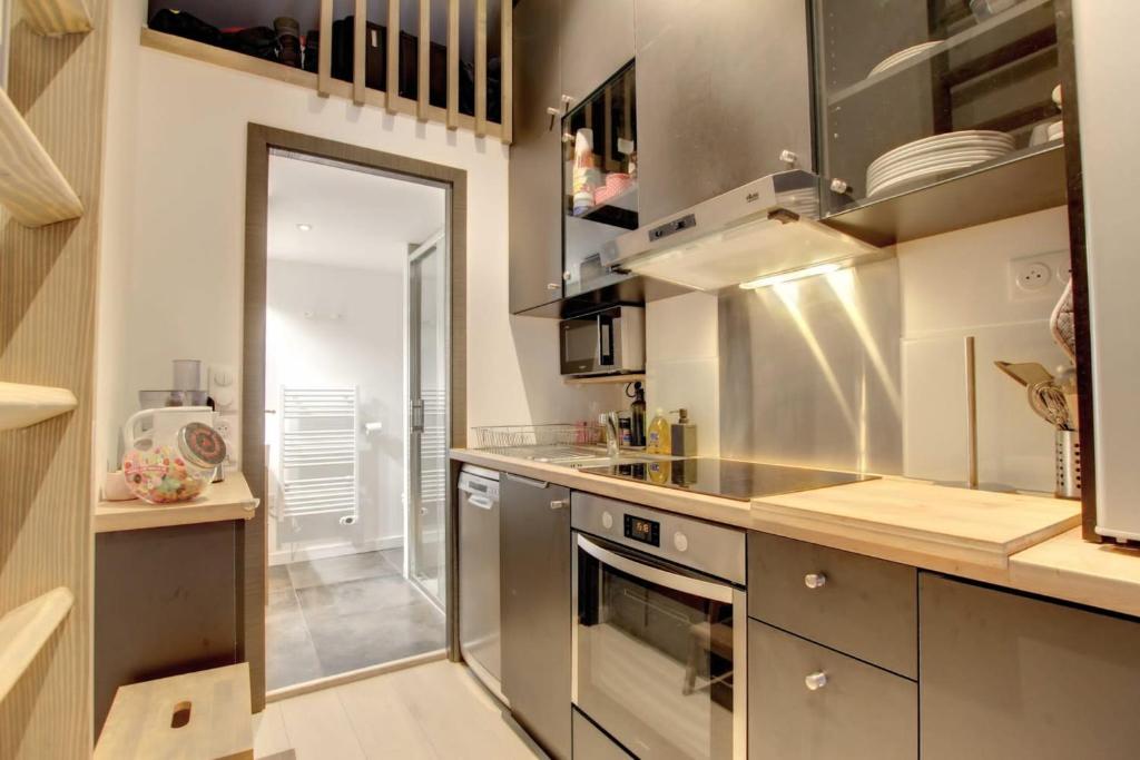 - une cuisine avec des placards en acier inoxydable et une cuisinière dans l'établissement Le Canal - Nice Studio on the Venice of the Alps, à Annecy