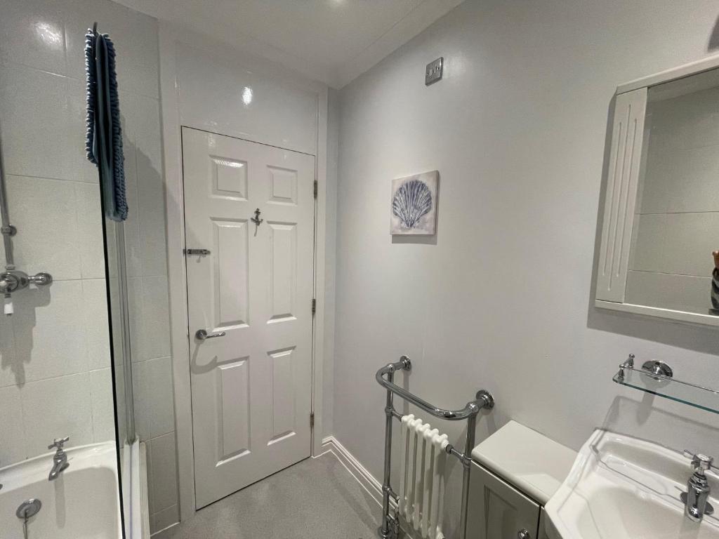 a bathroom with a shower and a white door at Entire Home between London and Kent- Mulberry House in Kent