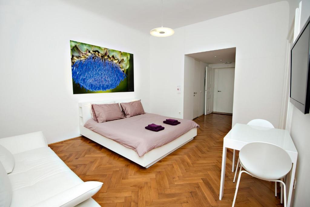 Cette chambre comprend un lit, une table et une chaise. dans l'établissement Galeria River, à Ljubljana