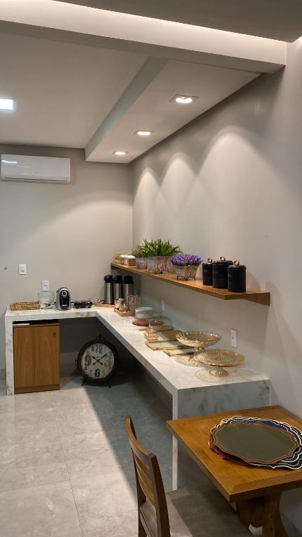 a kitchen with a table and a counter with dishes at Hotel Goiano in Estreito