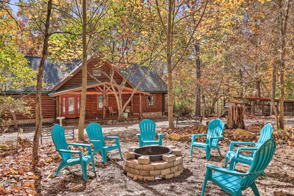 un grupo de sillas alrededor de una hoguera frente a una cabaña de madera en Serenity Woods Cabin with Hot Tub and Fire Pit, en Mountain Home