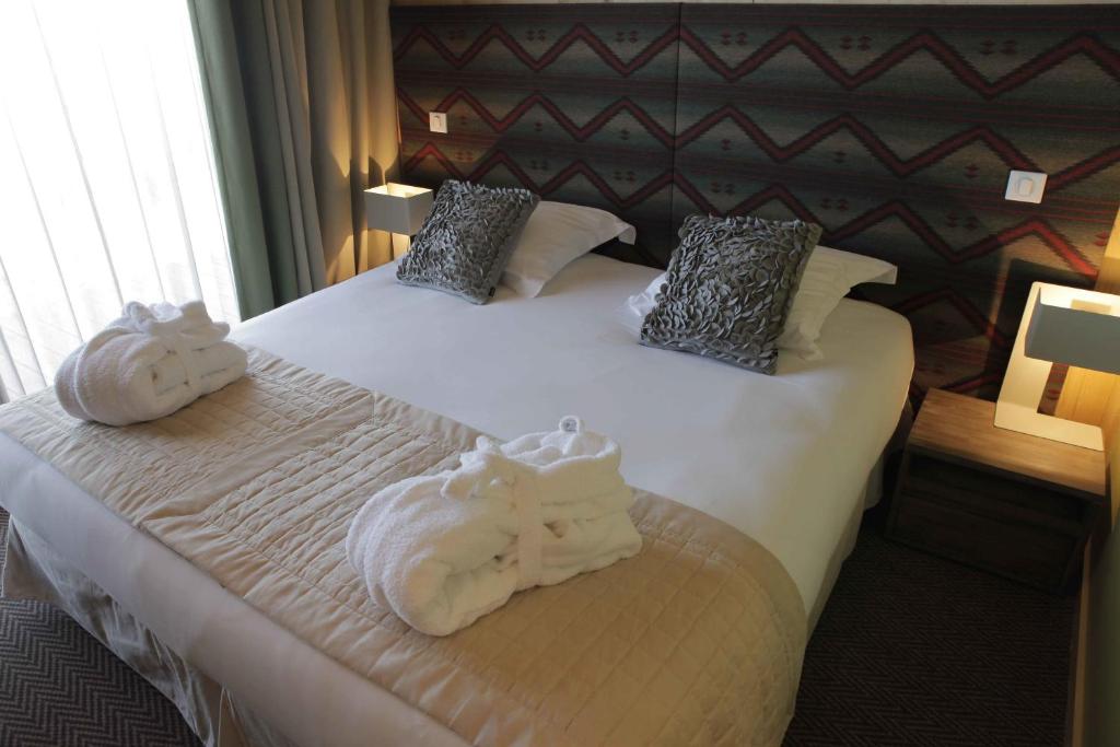 Postel nebo postele na pokoji v ubytování L'Aiguille Grive Chalets Hotel