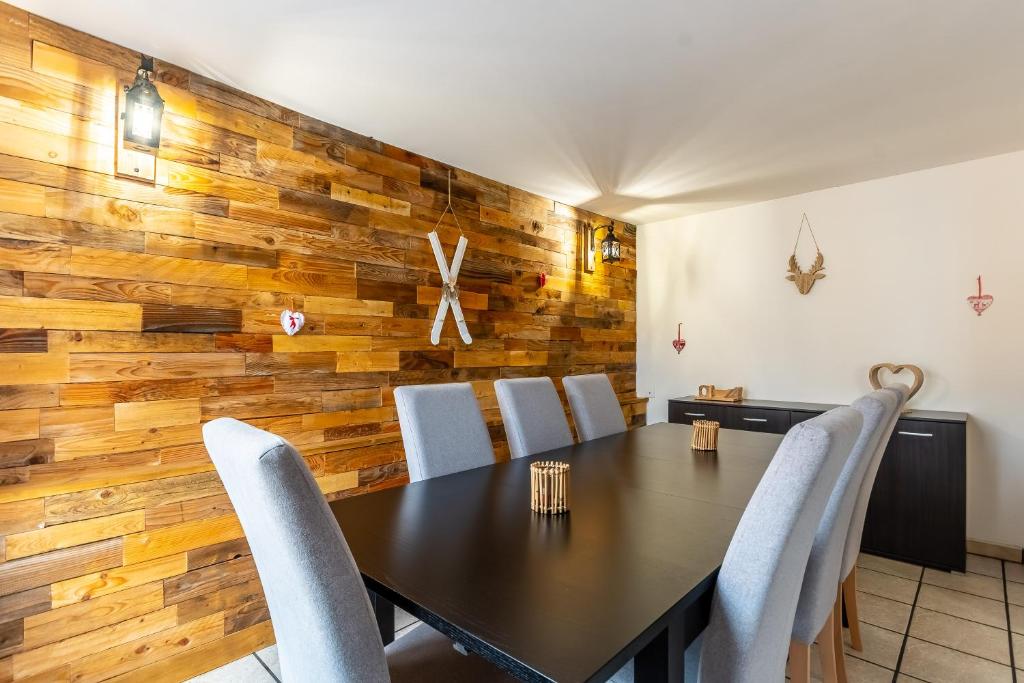 a dining room with a wooden wall with a table and chairs at Gite de la voie verte gitesdes2vallees in Cornimont