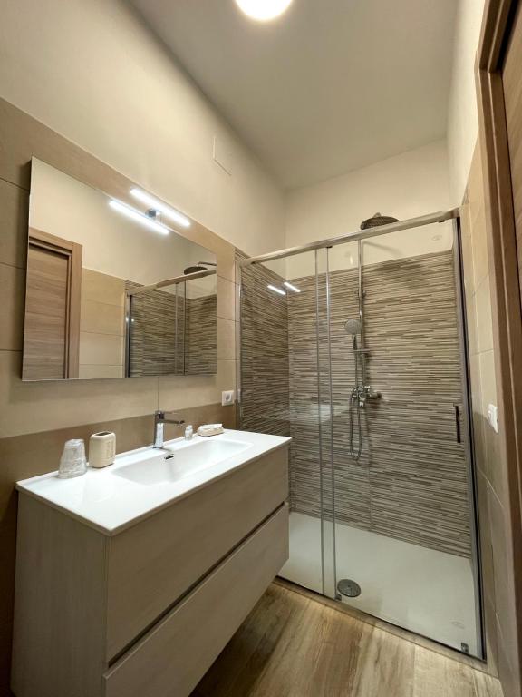 uma casa de banho com um lavatório e uma cabina de duche em vidro. em Dimora T'ama em San Lorenzello
