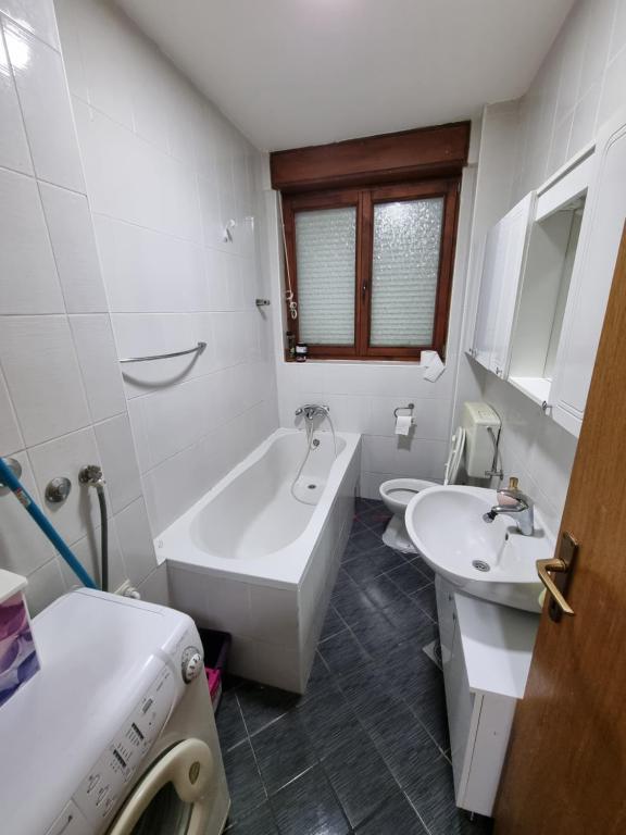 a bathroom with a tub and a sink and a bath tub at Apartman Danijela in Vukovar