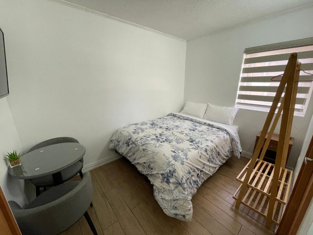 a small bedroom with a bed and a window at TinyApartments - estudio pleno centro Concepción in Concepción