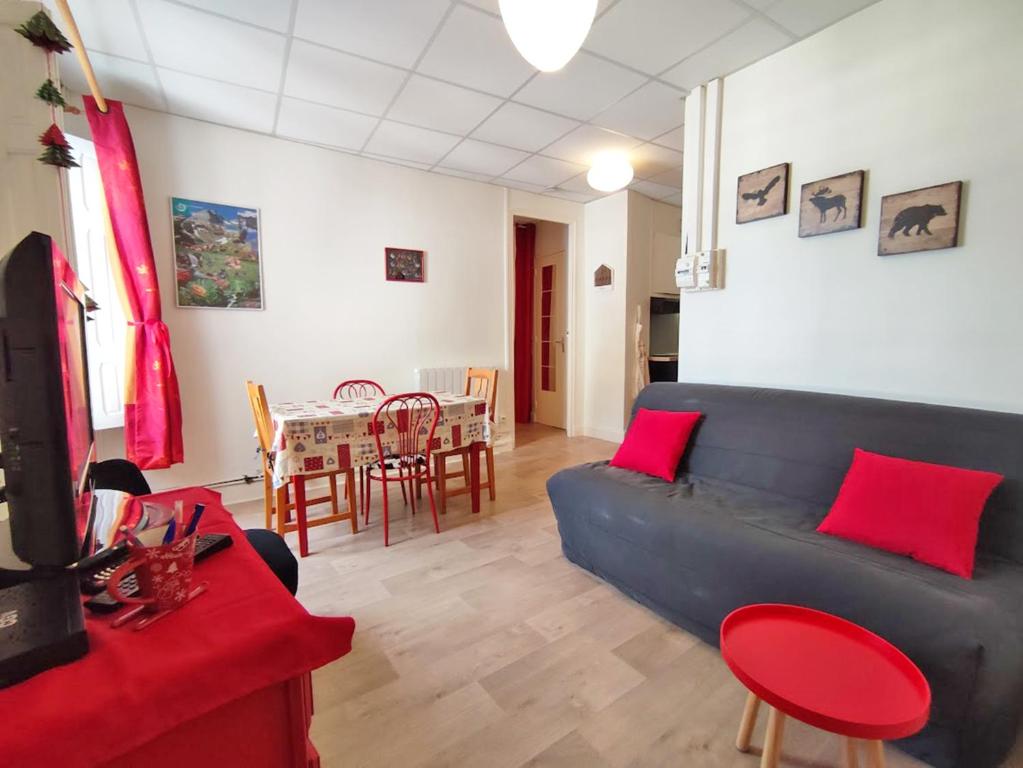 a living room with a blue couch and red pillows at Les 3 renards, T2 bis, parking, centre Luchon, casier à skis, 4 personnes in Luchon