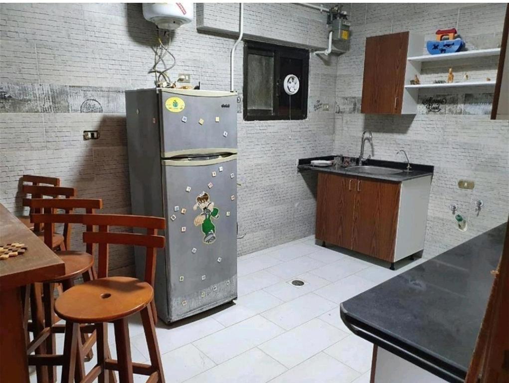 una cocina con nevera con pegatinas. en شقق فاخرة في المهندسين بالقاهره بكافة الخدمات, en El Cairo