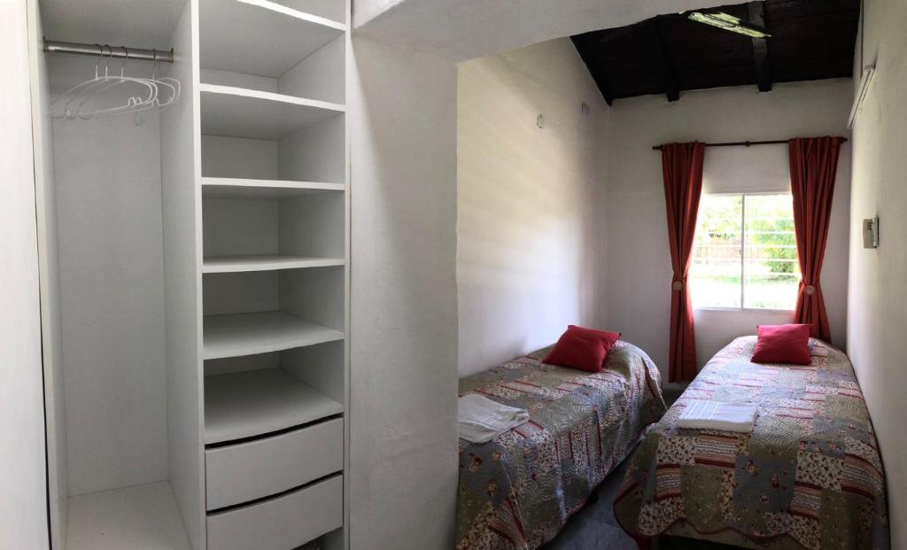 1 dormitorio con 2 camas y estante para libros en Rugidor Alojamientos en Corrientes