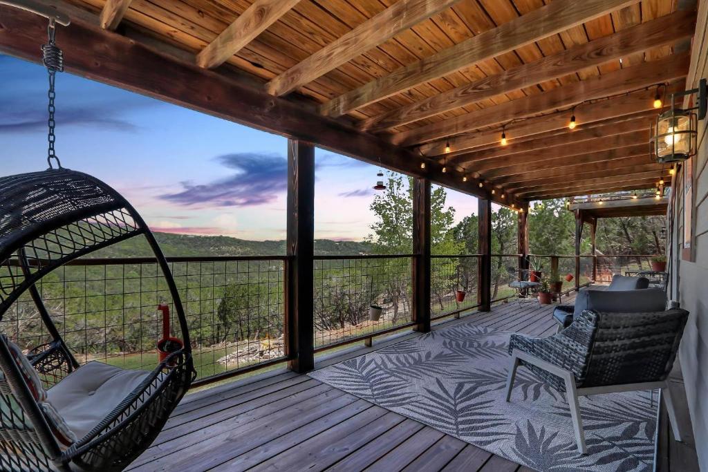 a porch with a hammock and chairs on a deck at Painted Paradise Guest Suite in New Braunfels