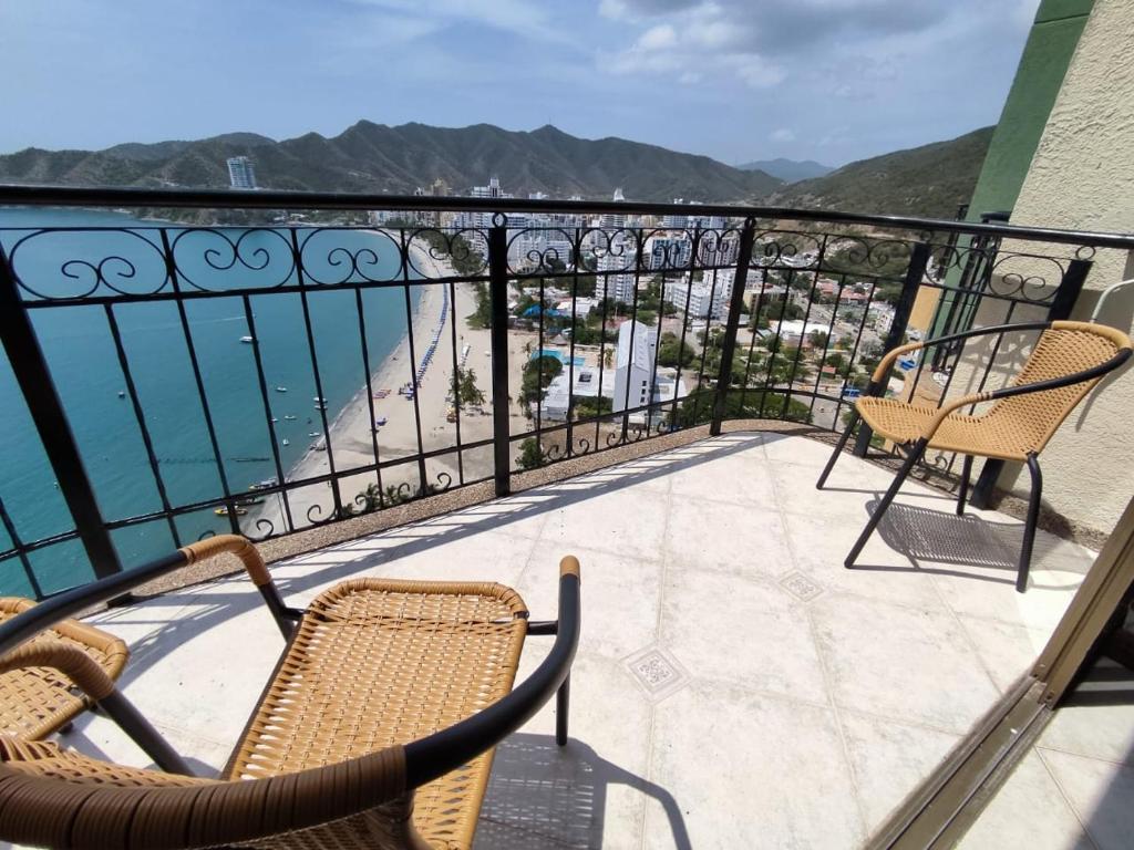 a balcony with chairs and a view of the ocean at Edif. el peñon espectacular vista in Santa Marta