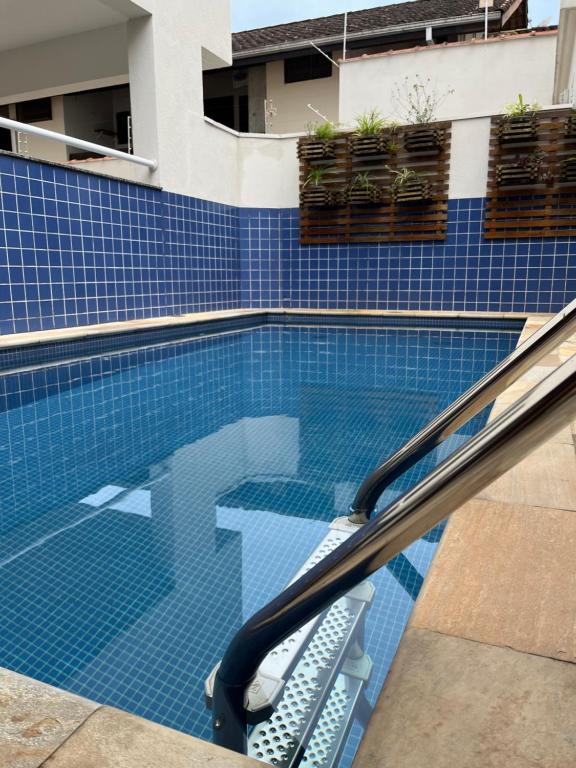 een zwembad met stoelen in een gebouw bij Apt 2 suites com ar condicionado e piscina Ubatuba in Ubatuba