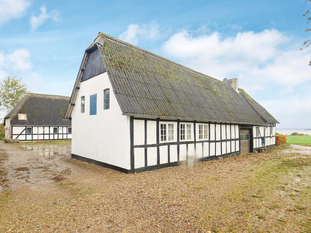 an old white building with a black roof at 4 person holiday home in Faaborg-By Traum in Bøjden