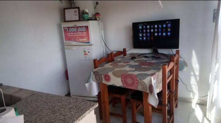 una pequeña cocina con mesa y nevera en Departamento Estrada en Tandil