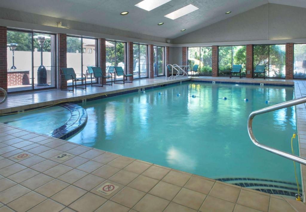 沃里克的住宿－普羅維斯登斯- 機場聖淘沙集團酒店，大楼内一个蓝色的大型游泳池