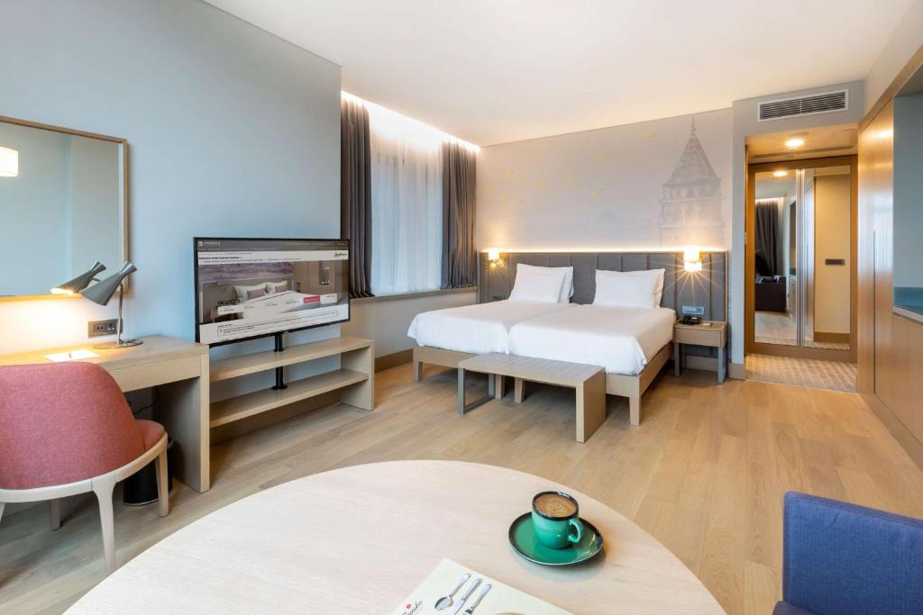 a hotel room with a bed and a tv at Radisson Hotel Istanbul Harbiye in Istanbul