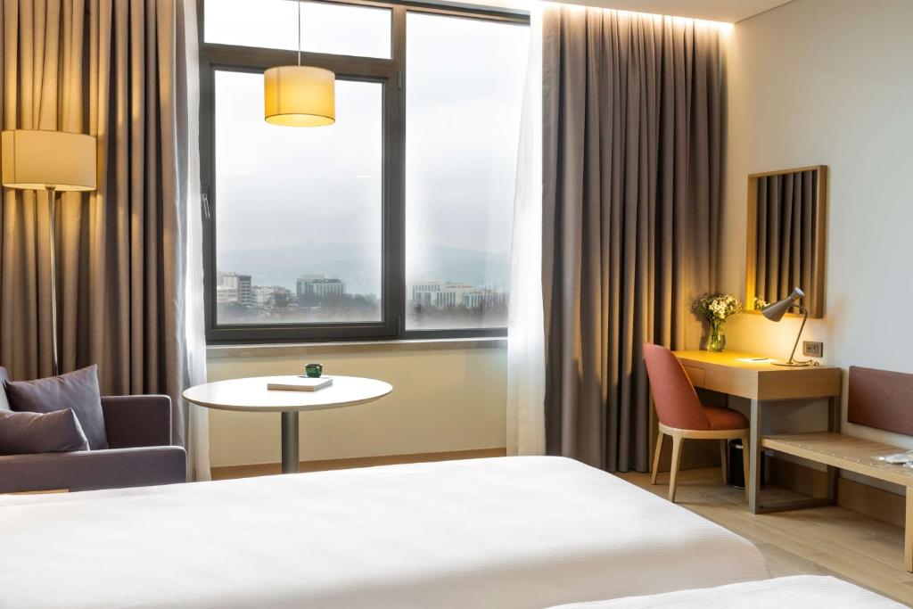a hotel room with a bed and a table and a window at Radisson Hotel Istanbul Harbiye in Istanbul