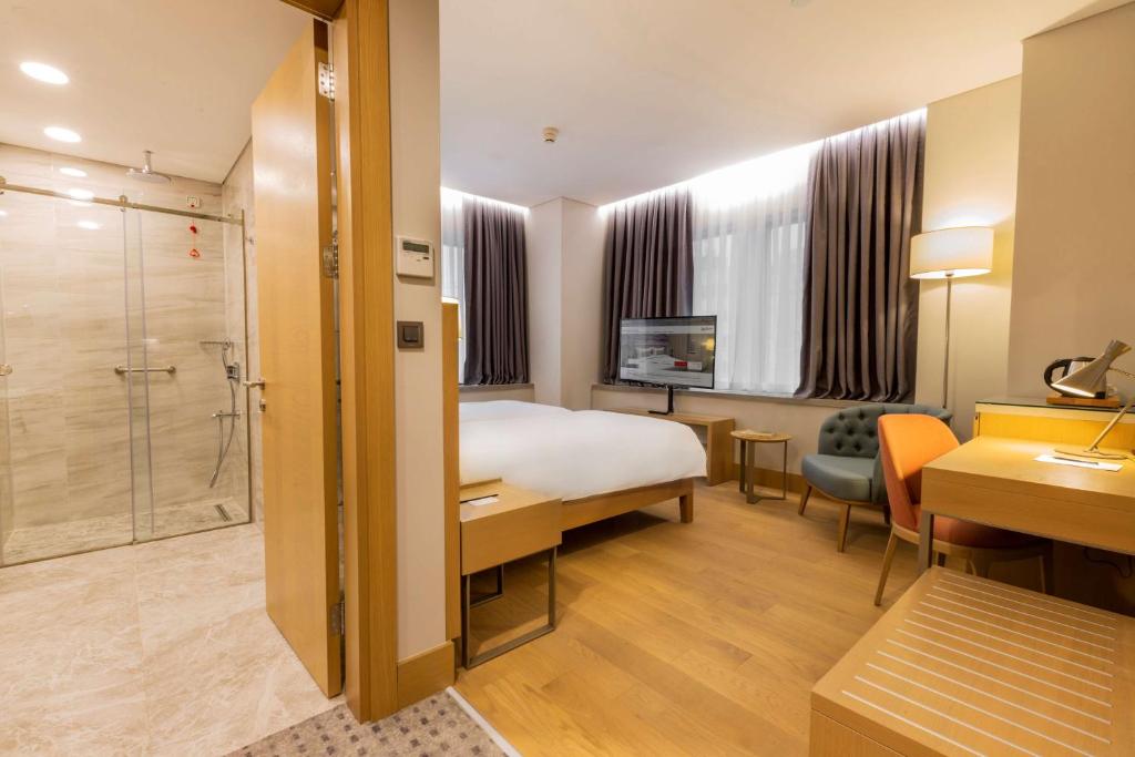 a hotel room with a bed and a bathroom at Radisson Hotel Istanbul Harbiye in Istanbul