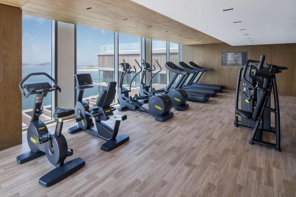 a gym with a row of treadms and cardio machines at Radisson Beach Resort Palm Jumeirah in Dubai