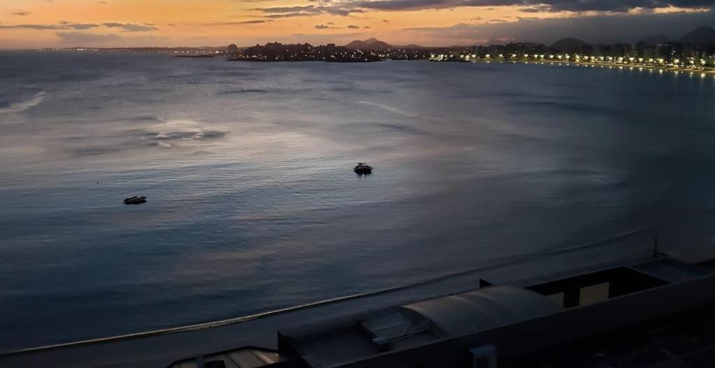 a view of a large body of water at sunset at Vista espectacular 180° Murano Praia do Morro in Guarapari
