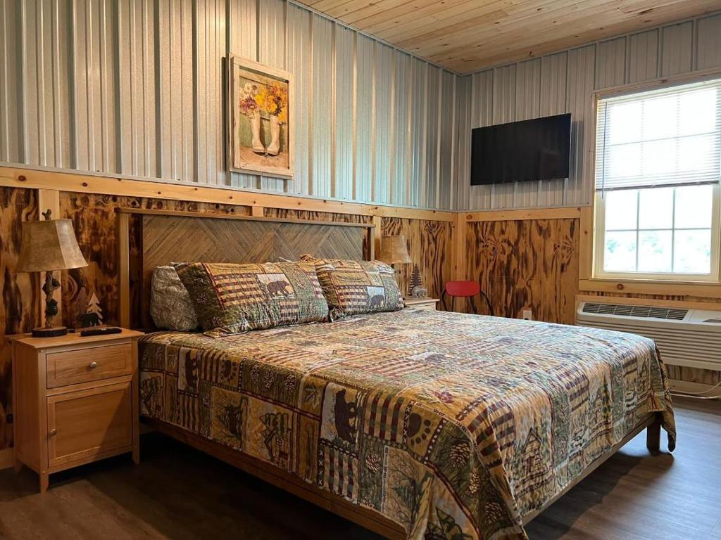 Brushcreek Falls RV Resort في برنستون: غرفة نوم بسرير كبير وتلفزيون