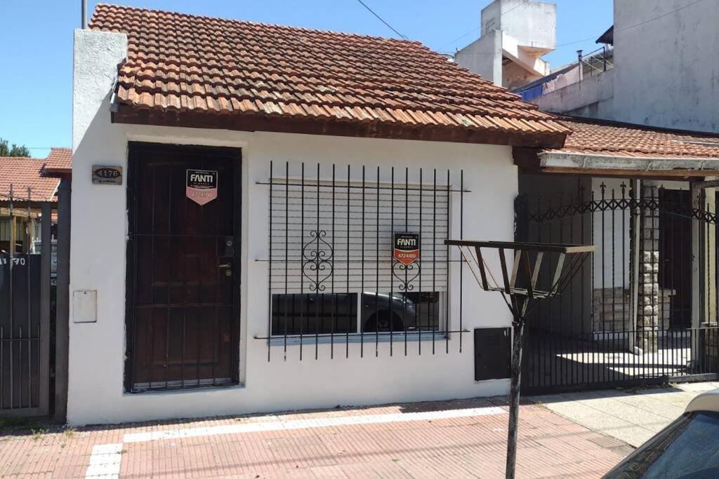 una pequeña casa blanca con una puerta y una puerta en Alquiler temporario 3 amb Parque Luro Mar del Plata en Mar del Plata