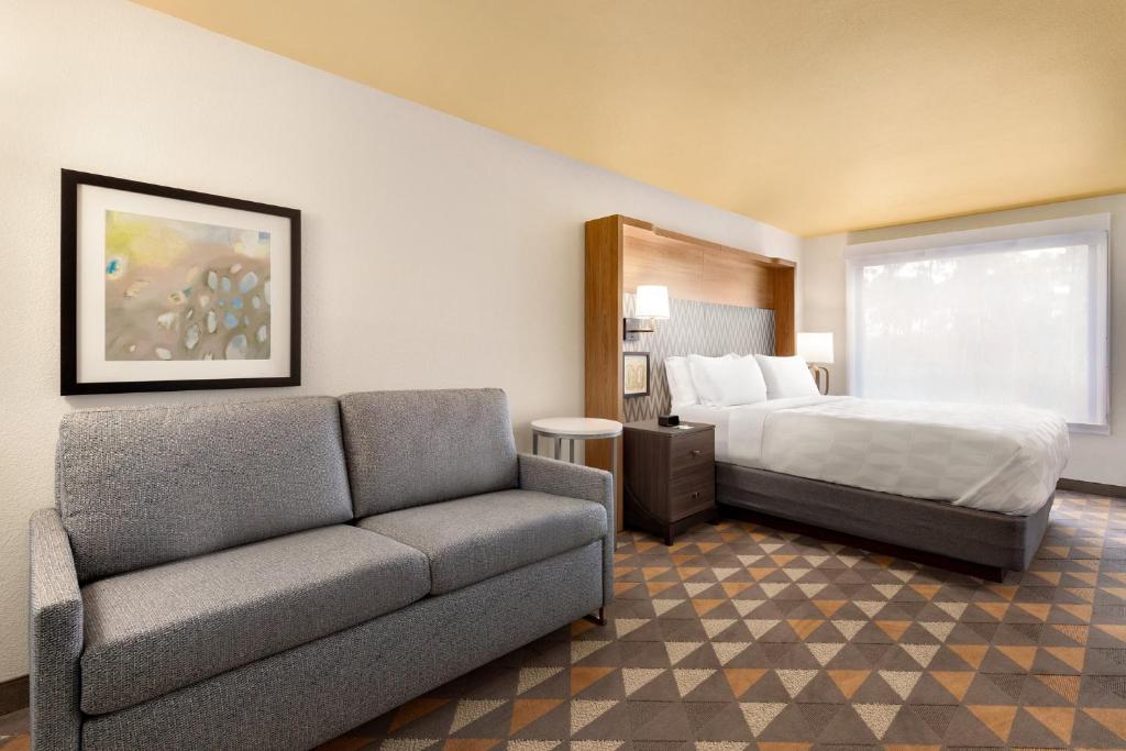 a hotel room with a couch and a bed at Holiday Inn Houston Intercontinental Airport by IHG in Houston