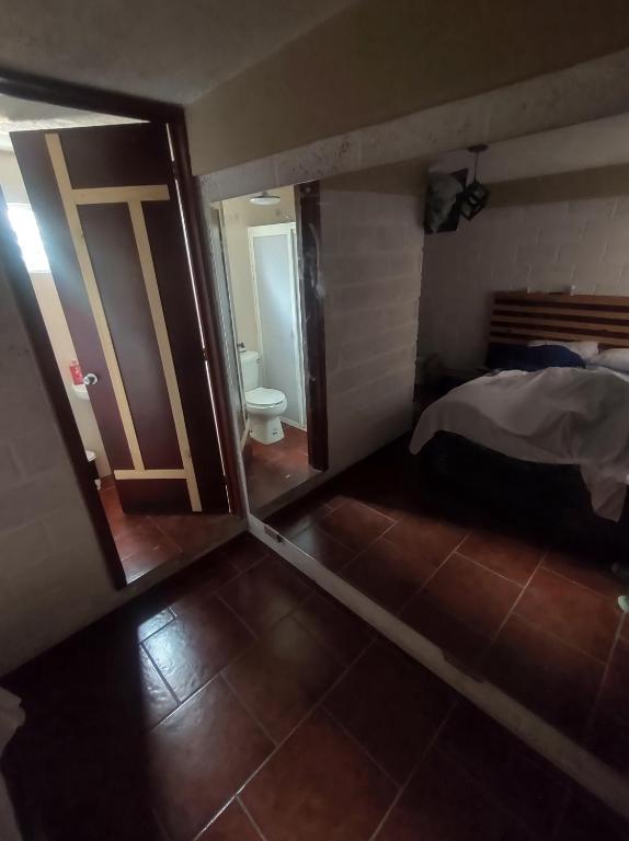 a room with a door and a bed and a bathroom at Cabañas Alicia in Mexico City