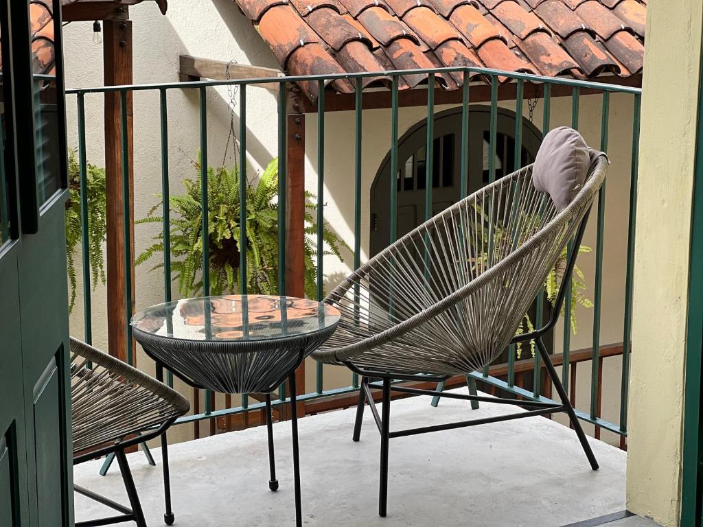 une paire de chaises et une table en verre sur un balcon dans l'établissement Corcho rooms, à Panama City