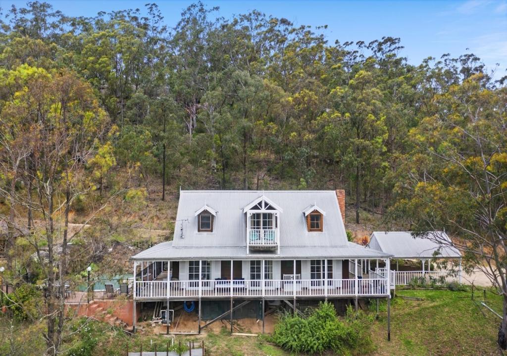 an aerial view of a white house with trees in the background at Cants Cottage in Broke